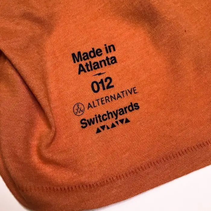 Switchyards and Alternative Apparel hem print on an orange shirt: Made in Atlanta, 012, and both logos
