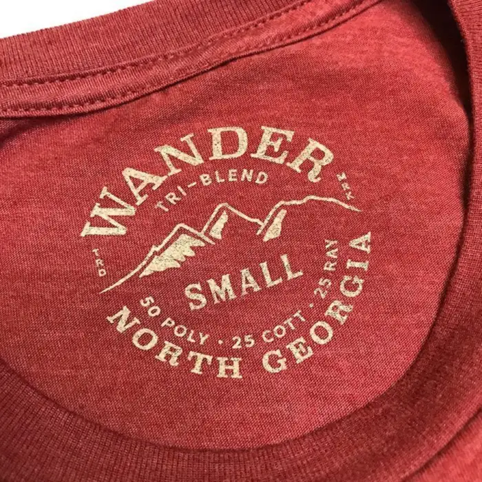 Wander North Georgia printed neck tag in cream ink on a red tri-blend shirt: a round badge with no outline, size Small