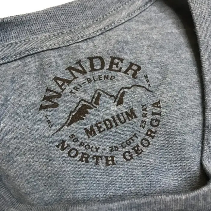 Wander North Georgia printed neck tag in brown ink on a blue tri-blend shirt, size Medium